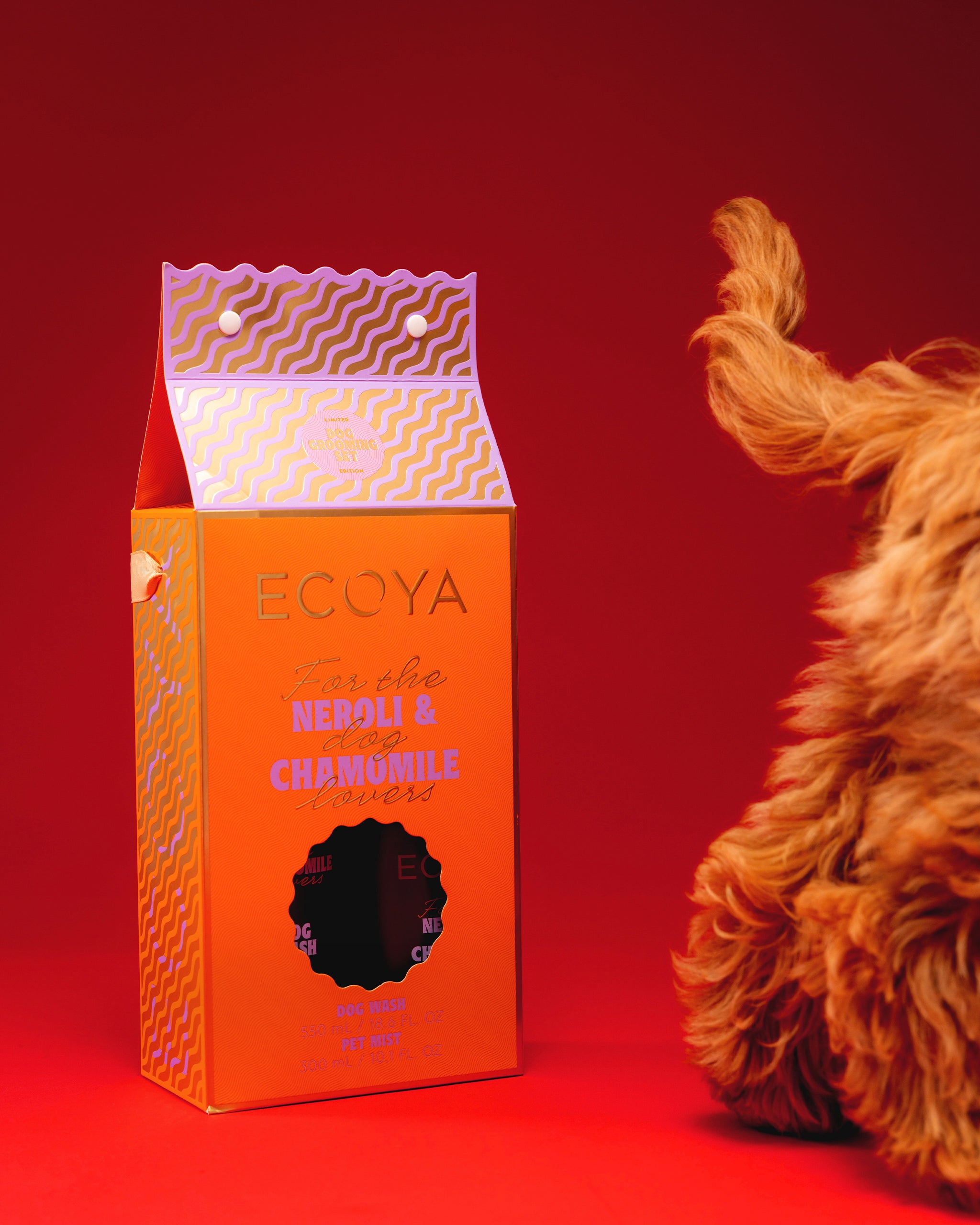 Ecoya dog grooming product packaging on a red background with a dog's tail visible