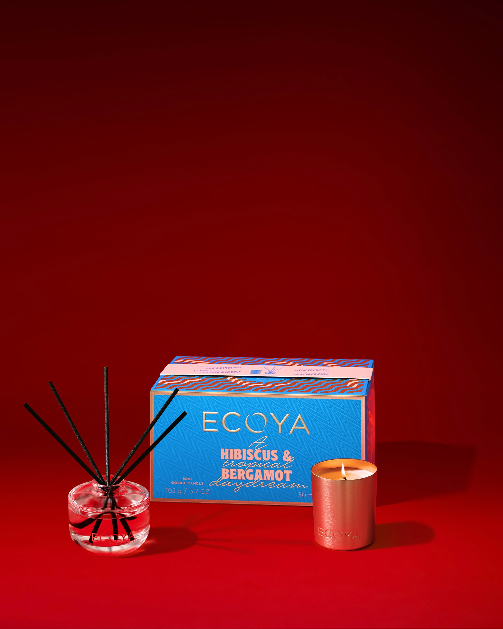 Ecoya scented candle, diffuser, and box on a red background