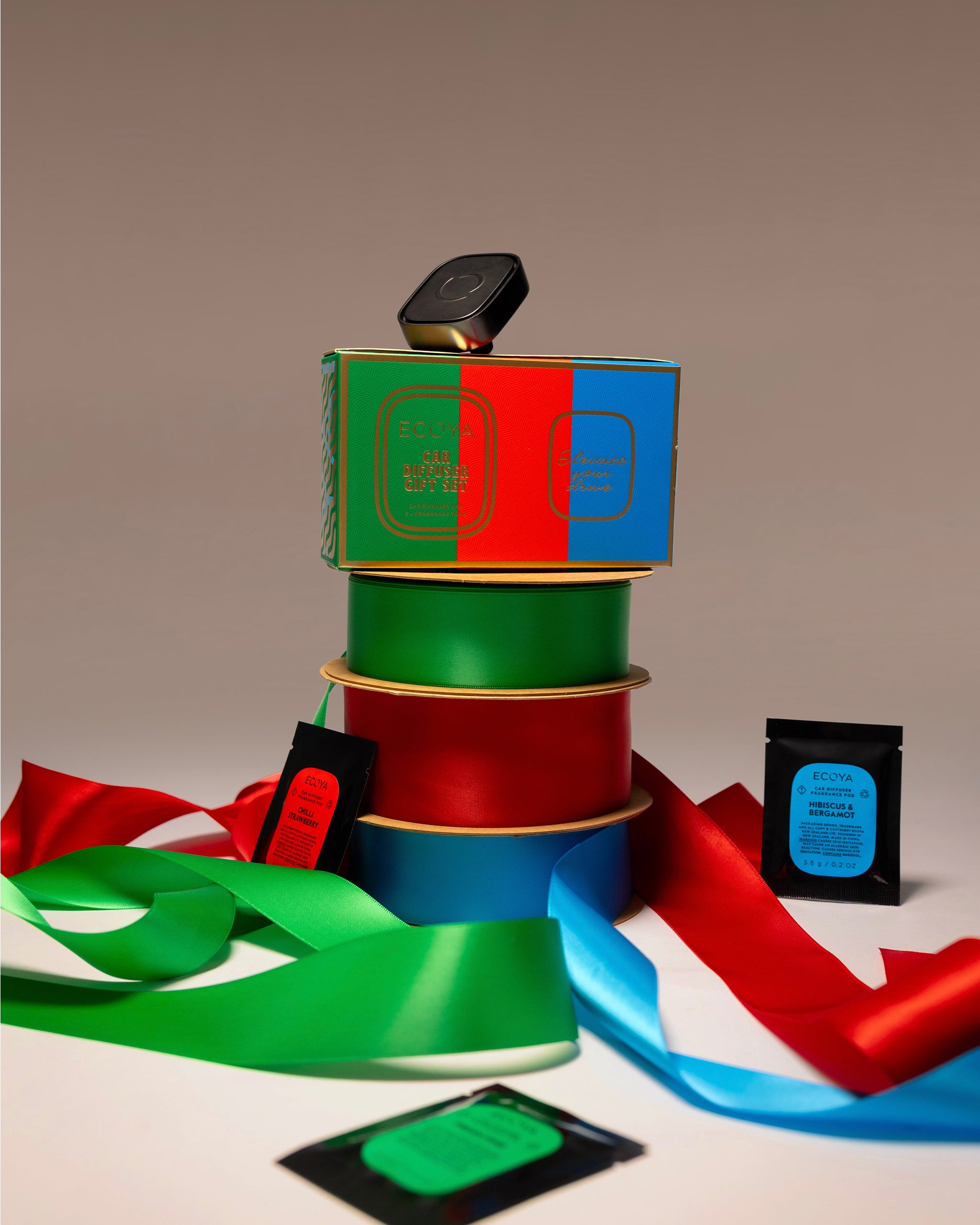 Stack of colorful spools with ribbons on a beige background